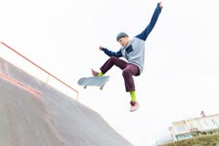 Ένας έφηβος skateboarder σε ένα καπέλο κάνει ένα τέχνασμα με ένα άλμα στην κεκλιμένη ράμπα Ένα skateboarder πετά στον αέρα στοκ φωτογραφίες με δικαίωμα ελεύθερης χρήσης Ένας έφηβος skateboarder σε ένα καπέλο κάνει ένα τέχνασμα με ένα άλμα στην κεκλιμένη ράμπα Ένα skateboarder πετά στον αέρα στοκ φωτογραφίες με δικαίωμα ελεύθερης χρήσης