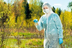 ένας ειδικός οικολόγος με μια φιάλη του νερού από μια δασική λίμνη διευθύνει στοκ φωτογραφία ένας ειδικός οικολόγος με μια φιάλη του νερού από μια δασική λίμνη διευθύνει στοκ φωτογραφία
