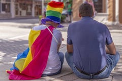 Ένας ενθαρρυντικός μπαμπάς κάθεται με την κόρη του στο φεστιβάλ υπερηφάνειας στοκ εικόνες Ένας ενθαρρυντικός μπαμπάς κάθεται με την κόρη του στο φεστιβάλ υπερηφάνειας στοκ εικόνες