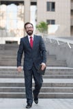 Ένας επιχειρηματίας που περπατά κάτω στο κέντρο γραφείων με μια ταμπλέτα στο χέρι Ο επιτυχής γενειοφόρος επιχειρηματίας είναι ευτ στοκ φωτογραφίες με δικαίωμα ελεύθερης χρήσης Ένας επιχειρηματίας που περπατά κάτω στο κέντρο γραφείων με μια ταμπλέτα στο χέρι Ο επιτυχής γενειοφόρος επιχειρηματίας είναι ευτ στοκ φωτογραφίες με δικαίωμα ελεύθερης χρήσης