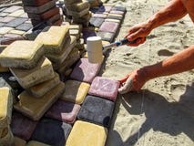 Ένας εργαζόμενος στο στάδιο της τοποθέτησης των πολύχρωμων πλακών επίστρωσης στοκ εικόνα Ένας εργαζόμενος στο στάδιο της τοποθέτησης των πολύχρωμων πλακών επίστρωσης στοκ εικόνα