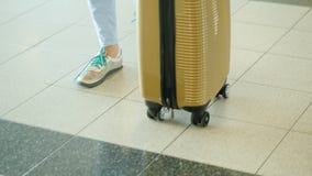 Ένας θηλυκός ταξιδιώτης με μια τσάντα στις ρόδες περπατά κατά μήκος του τερματικού αερολιμένων Στο πλαίσιο μόνο τα πόδια είναι ορ απόθεμα βίντεο Ένας θηλυκός ταξιδιώτης με μια τσάντα στις ρόδες περπατά κατά μήκος του τερματικού αερολιμένων Στο πλαίσιο μόνο τα πόδια είναι ορ απόθεμα βίντεο