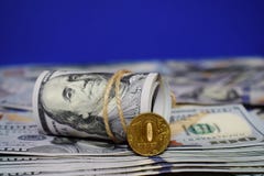 Ένας ρόλος των δολαρίων και ένα νόμισμα 10 ρωσικών ρουβλιών στο υπόβαθρο των διεσπαρμένων λογαριασμών εκατό δολαρίων στοκ φωτογραφία με δικαίωμα ελεύθερης χρήσης Ένας ρόλος των δολαρίων και ένα νόμισμα 10 ρωσικών ρουβλιών στο υπόβαθρο των διεσπαρμένων λογαριασμών εκατό δολαρίων στοκ φωτογραφία με δικαίωμα ελεύθερης χρήσης