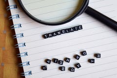 Έννοια Translate της λέξης στους ξύλινους κύβους με τα βιβλία στο υπόβαθρο στοκ φωτογραφία Έννοια Translate της λέξης στους ξύλινους κύβους με τα βιβλία στο υπόβαθρο στοκ φωτογραφία