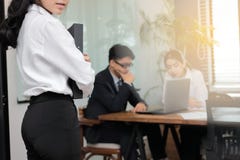 Έννοια επιχειρησιακών γυναικών ηγεσίας Καλλιεργημένη εικόνα της νέας ασιατικής επιχειρηματία που στέκεται ενάντια στο συνάδελφό τ στοκ εικόνες Έννοια επιχειρησιακών γυναικών ηγεσίας Καλλιεργημένη εικόνα της νέας ασιατικής επιχειρηματία που στέκεται ενάντια στο συνάδελφό τ στοκ εικόνες