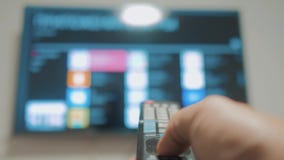 Έξυπνη TV με τα apps και το χέρι Το αρσενικό χέρι που κρατά τον τηλεχειρισμό κλείνει την έξυπνη TV εκμετάλλευση TV ελέγχων χεριών φιλμ μικρού μήκους Έξυπνη TV με τα apps και το χέρι Το αρσενικό χέρι που κρατά τον τηλεχειρισμό κλείνει την έξυπνη TV εκμετάλλευση TV ελέγχων χεριών φιλμ μικρού μήκους