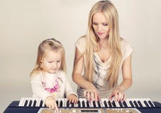 λίγο χαριτωμένο κορίτσι με το mom της που παίζει στο συνθέτη στοκ εικόνες λίγο χαριτωμένο κορίτσι με το mom της που παίζει στο συνθέτη στοκ εικόνες