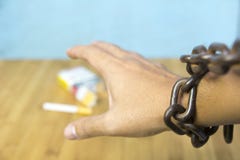 Αλυσοδεμένο ανθρώπινο χέρι που προσπαθεί να πιάσει το τσιγάρο στον πίνακα στοκ εικόνες με δικαίωμα ελεύθερης χρήσης Αλυσοδεμένο ανθρώπινο χέρι που προσπαθεί να πιάσει το τσιγάρο στον πίνακα στοκ εικόνες με δικαίωμα ελεύθερης χρήσης