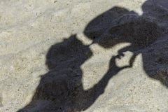 Αγάπη των σκιών ζευγών που κάνουν ένα φιλί στην τροπική παραλία άμμου Στοκ Εικόνες Αγάπη των σκιών ζευγών που κάνουν ένα φιλί στην τροπική παραλία άμμου Στοκ Εικόνες