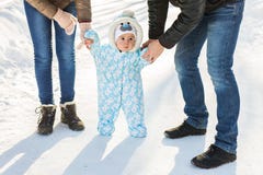 Αγοράκι στο θερμό snowsuit που περπατά στο χειμερινό πάρκο με τους γονείς Πρώτος χειμώνας και πρώτα βήματα μικρών παιδιών στο χιό Στοκ Εικόνες Αγοράκι στο θερμό snowsuit που περπατά στο χειμερινό πάρκο με τους γονείς Πρώτος χειμώνας και πρώτα βήματα μικρών παιδιών στο χιό Στοκ Εικόνες