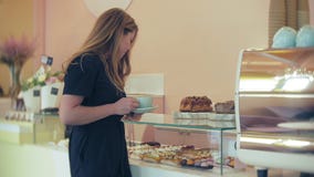 Αγοραστής επιλέγει yummy Το νέο ελκυστικό κορίτσι, γυναίκα αγοράζει στη καφετερία ή τις ζύμες, κέικ, κέικ, macaroon Α απόθεμα βίντεο Αγοραστής επιλέγει yummy Το νέο ελκυστικό κορίτσι, γυναίκα αγοράζει στη καφετερία ή τις ζύμες, κέικ, κέικ, macaroon Α απόθεμα βίντεο