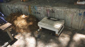 Αγροτική άσπρη έδρα σκαμνιών με το σωρό της θυμωνιάς χόρτου αχύρου δίπλα στο βρώμικο χρωματισμένο τοίχο στοκ εικόνες Αγροτική άσπρη έδρα σκαμνιών με το σωρό της θυμωνιάς χόρτου αχύρου δίπλα στο βρώμικο χρωματισμένο τοίχο στοκ εικόνες