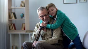 Αγόρι που αγκαλιάζει tenderly τον παππού, οικογενειακή αγάπη, σεβασμός της παλαιότερης γενεάς στοκ εικόνες Αγόρι που αγκαλιάζει tenderly τον παππού, οικογενειακή αγάπη, σεβασμός της παλαιότερης γενεάς στοκ εικόνες