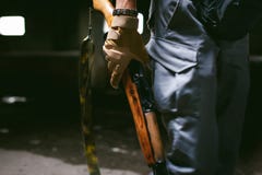 Αθλητικό άτομο στα γκρίζα ενδύματα με ένα πυροβόλο όπλο carbine στο χέρι του στοκ φωτογραφίες με δικαίωμα ελεύθερης χρήσης Αθλητικό άτομο στα γκρίζα ενδύματα με ένα πυροβόλο όπλο carbine στο χέρι του στοκ φωτογραφίες με δικαίωμα ελεύθερης χρήσης