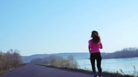 Αθλητικό κοριτσιών κατά μήκος της όχθης ποταμού κατά τη διάρκεια της ανατολής ή του ηλιοβασιλέματος η υγιής έννοια τρόπου ζωής τη απόθεμα βίντεο Αθλητικό κοριτσιών κατά μήκος της όχθης ποταμού κατά τη διάρκεια της ανατολής ή του ηλιοβασιλέματος η υγιής έννοια τρόπου ζωής τη απόθεμα βίντεο