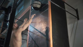 Αθλητικός τύπος που ρίχνει τη σφαίρα βάρους στον τοίχο απόθεμα βίντεο Αθλητικός τύπος που ρίχνει τη σφαίρα βάρους στον τοίχο απόθεμα βίντεο