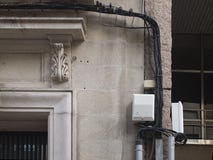 Ακατάστατα καλώδια τηλεφώνων ή ηλεκτρικής ενέργειας που κρεμιούνται σε έναν τοίχο πετρών στοκ φωτογραφία με δικαίωμα ελεύθερης χρήσης Ακατάστατα καλώδια τηλεφώνων ή ηλεκτρικής ενέργειας που κρεμιούνται σε έναν τοίχο πετρών στοκ φωτογραφία με δικαίωμα ελεύθερης χρήσης