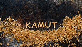 Ακατέργαστο σιτάρι Kamut με μια τοπ άποψη Kamut λέξης στοκ φωτογραφίες Ακατέργαστο σιτάρι Kamut με μια τοπ άποψη Kamut λέξης στοκ φωτογραφίες
