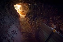 Αμυδρή σήραγγα κακώς αναμμένη από το λαμπτήρα στο τέλος στοκ εικόνες Αμυδρή σήραγγα κακώς αναμμένη από το λαμπτήρα στο τέλος στοκ εικόνες