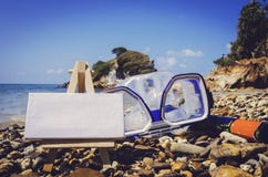 Αναδρομικός και τρύγος φανείτε κενό άσπρο πλαίσιο καμβά έννοιας εικόνας με easel στην παραλία Τα προστατευτικά δίοπτρα κατάδυσης Στοκ φωτογραφίες με δικαίωμα ελεύθερης χρήσης Αναδρομικός και τρύγος φανείτε κενό άσπρο πλαίσιο καμβά έννοιας εικόνας με easel στην παραλία Τα προστατευτικά δίοπτρα κατάδυσης Στοκ φωτογραφίες με δικαίωμα ελεύθερης χρήσης