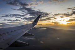 Ανατολή από ένα αεροπλάνο κατά την πτήση με την άποψη του φτερού του και του ήλιου πίσω Στοκ Εικόνες Ανατολή από ένα αεροπλάνο κατά την πτήση με την άποψη του φτερού του και του ήλιου πίσω Στοκ Εικόνες