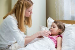 Ανησυχημένη μητέρα που δίνει την ιατρική στο άρρωστο παιδί της στοκ εικόνες Ανησυχημένη μητέρα που δίνει την ιατρική στο άρρωστο παιδί της στοκ εικόνες