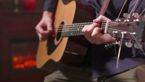 Ανθρώπινα χέρια που κρατούν μια ακουστική κιθάρα και που εκτελούν μια σύνθεση απόθεμα βίντεο Ανθρώπινα χέρια που κρατούν μια ακουστική κιθάρα και που εκτελούν μια σύνθεση απόθεμα βίντεο
