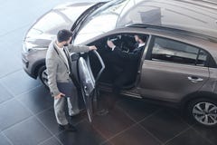 Ανοίγοντας πόρτα πωλητών αυτοκινήτων στον πελάτη στοκ φωτογραφίες Ανοίγοντας πόρτα πωλητών αυτοκινήτων στον πελάτη στοκ φωτογραφίες