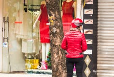 ΑΝΟΙ, ΒΙΕΤΝΑΜ - 16 ΔΕΚΕΜΒΡΊΟΥ 2016: Μια γυναίκα σε ένα κόκκινο σακάκι στο υπόβαθρο των καταστημάτων Διάστημα αντιγράφων για το κε στοκ εικόνες ΑΝΟΙ, ΒΙΕΤΝΑΜ - 16 ΔΕΚΕΜΒΡΊΟΥ 2016: Μια γυναίκα σε ένα κόκκινο σακάκι στο υπόβαθρο των καταστημάτων Διάστημα αντιγράφων για το κε στοκ εικόνες
