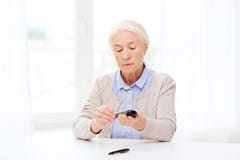 Ανώτερη γυναίκα με το glucometer που ελέγχει τη ζάχαρη αίματος στοκ εικόνες Ανώτερη γυναίκα με το glucometer που ελέγχει τη ζάχαρη αίματος στοκ εικόνες