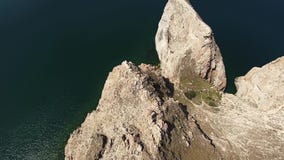 Απίστευτη τοπ 4k εναέρια άποψη κηφήνων σχετικά με τον τεράστιο απότομο βράχο βουνών βράχου πετρών Baikal λιμνών ήρεμο seascape τη φιλμ μικρού μήκους Απίστευτη τοπ 4k εναέρια άποψη κηφήνων σχετικά με τον τεράστιο απότομο βράχο βουνών βράχου πετρών Baikal λιμνών ήρεμο seascape τη φιλμ μικρού μήκους