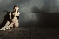 Απογοητευμένη συνεδρίαση χορευτών μπαλέτου στο σκοτεινό αναμμένο δωμάτιο στοκ φωτογραφία με δικαίωμα ελεύθερης χρήσης Απογοητευμένη συνεδρίαση χορευτών μπαλέτου στο σκοτεινό αναμμένο δωμάτιο στοκ φωτογραφία με δικαίωμα ελεύθερης χρήσης