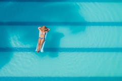 Απόλαυση suntan όμορφες νεολαίες γυναικών διακοπών λιμνών έννοιας Τοπ άποψη της λεπτής νέας γυναίκας στο μπικίνι στο μπλε στρώμα στοκ εικόνα Απόλαυση suntan όμορφες νεολαίες γυναικών διακοπών λιμνών έννοιας Τοπ άποψη της λεπτής νέας γυναίκας στο μπικίνι στο μπλε στρώμα στοκ εικόνα