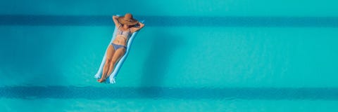 Απόλαυση suntan όμορφες νεολαίες γυναικών διακοπών λιμνών έννοιας Τοπ άποψη της λεπτής νέας γυναίκας στο μπικίνι στο μπλε στρώμα στοκ φωτογραφία με δικαίωμα ελεύθερης χρήσης Απόλαυση suntan όμορφες νεολαίες γυναικών διακοπών λιμνών έννοιας Τοπ άποψη της λεπτής νέας γυναίκας στο μπικίνι στο μπλε στρώμα στοκ φωτογραφία με δικαίωμα ελεύθερης χρήσης