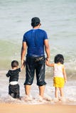 Αραβικός πατέρας με δύο παιδιά που κρατούν τα χέρια θαλασσίως Αραβικός πατέρας με δύο παιδιά που κρατούν τα χέρια θαλασσίως