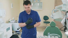 Αργά παίρνοντας τις εικόνες των νέων πορτρέτων γιατρών ` s ένα άτομο στο οδοντικό γραφείο του προετοιμάζεται να λάβει έναν ασθενή απόθεμα βίντεο Αργά παίρνοντας τις εικόνες των νέων πορτρέτων γιατρών ` s ένα άτομο στο οδοντικό γραφείο του προετοιμάζεται να λάβει έναν ασθενή απόθεμα βίντεο