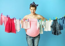 Αρκετά έγκυο mom που κάνει το πλυντήριο στοκ εικόνες Αρκετά έγκυο mom που κάνει το πλυντήριο στοκ εικόνες