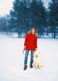 Αρκετά νέα γυναίκα με το άσπρο σκυλί Samoyed μαζί στο χιόνι στη χειμερινή ημέρα, που περπατά στο δάσος πάρκων στοκ εικόνα Αρκετά νέα γυναίκα με το άσπρο σκυλί Samoyed μαζί στο χιόνι στη χειμερινή ημέρα, που περπατά στο δάσος πάρκων στοκ εικόνα