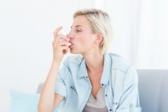 Αρκετά ξανθή γυναίκα που χρησιμοποιεί inhaler της στοκ εικόνα με δικαίωμα ελεύθερης χρήσης Αρκετά ξανθή γυναίκα που χρησιμοποιεί inhaler της στοκ εικόνα με δικαίωμα ελεύθερης χρήσης