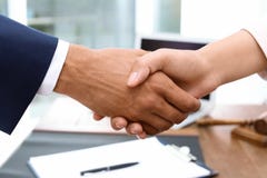 Αρσενικά χέρια τινάγματος δικηγόρων με τη γυναίκα πέρα από τον πίνακα στοκ εικόνες Αρσενικά χέρια τινάγματος δικηγόρων με τη γυναίκα πέρα από τον πίνακα στοκ εικόνες