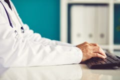 Αρσενικές εργασίες γιατρών με τον υπολογιστή στοκ φωτογραφία Αρσενικές εργασίες γιατρών με τον υπολογιστή στοκ φωτογραφία