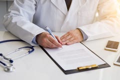 Αρσενική συνεδρίαση γιατρών στις σημειώσεις γραφείων και γραψίματος για την περιοχή αποκομμάτων στοκ εικόνα με δικαίωμα ελεύθερης χρήσης Αρσενική συνεδρίαση γιατρών στις σημειώσεις γραφείων και γραψίματος για την περιοχή αποκομμάτων στοκ εικόνα με δικαίωμα ελεύθερης χρήσης