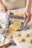 Αρσενικός αρχιμάγειρας που κατασκευάζει ravioli με τη μηχανή ζυμαρικών στοκ φωτογραφίες με δικαίωμα ελεύθερης χρήσης Αρσενικός αρχιμάγειρας που κατασκευάζει ravioli με τη μηχανή ζυμαρικών στοκ φωτογραφίες με δικαίωμα ελεύθερης χρήσης
