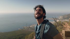Αρσενικός οδοιπόρος με το σακίδιο πλάτης που φαίνεται εν πλω ενάντια στον ουρανό απόθεμα βίντεο Αρσενικός οδοιπόρος με το σακίδιο πλάτης που φαίνεται εν πλω ενάντια στον ουρανό απόθεμα βίντεο