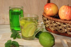 Ασβέστης goblets γυαλιού και φρούτα με τη μέντα σε έναν ξύλινο πίνακα στοκ εικόνες Ασβέστης goblets γυαλιού και φρούτα με τη μέντα σε έναν ξύλινο πίνακα στοκ εικόνες