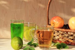 Ασβέστης goblets γυαλιού και φρούτα με τη μέντα σε έναν ξύλινο πίνακα στοκ εικόνα με δικαίωμα ελεύθερης χρήσης Ασβέστης goblets γυαλιού και φρούτα με τη μέντα σε έναν ξύλινο πίνακα στοκ εικόνα με δικαίωμα ελεύθερης χρήσης