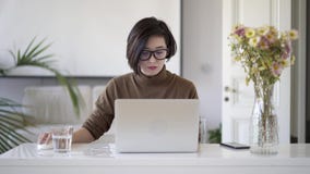 Ασιατική γυναίκα eyeglasses που λειτουργούν με το lap-top στο άσπρο Υπουργείο Εσωτερικών φιλμ μικρού μήκους Ασιατική γυναίκα eyeglasses που λειτουργούν με το lap-top στο άσπρο Υπουργείο Εσωτερικών φιλμ μικρού μήκους