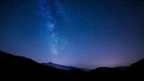 Αστέρια νυχτερινού ουρανού Timelapse με το γαλακτώδη τρόπο στο υπόβαθρο βουνών Αστέρια νυχτερινού ουρανού Timelapse με το γαλακτώδη τρόπο στο υπόβαθρο βουνών
