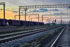 Αυτοκινητάμαξα για το ξηρό φορτίο κατά τη διάρκεια του όμορφου ηλιοβασιλέματος και του ζωηρόχρωμου ουρανού, της υποδομής σιδηροδρ Στοκ Εικόνα Αυτοκινητάμαξα για το ξηρό φορτίο κατά τη διάρκεια του όμορφου ηλιοβασιλέματος και του ζωηρόχρωμου ουρανού, της υποδομής σιδηροδρ Στοκ Εικόνα