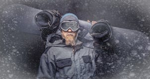 Βάναυσο redhead snowboarder με μια πλήρη γενειάδα σε ένα χειμερινό καπέλο και προστατευτικά γυαλιά που ντύνονται σε ένα snowboard στοκ φωτογραφία με δικαίωμα ελεύθερης χρήσης Βάναυσο redhead snowboarder με μια πλήρη γενειάδα σε ένα χειμερινό καπέλο και προστατευτικά γυαλιά που ντύνονται σε ένα snowboard στοκ φωτογραφία με δικαίωμα ελεύθερης χρήσης